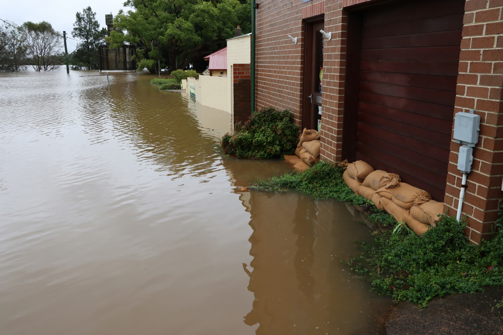 Floodwater and sandbags stacked against the doors of a home