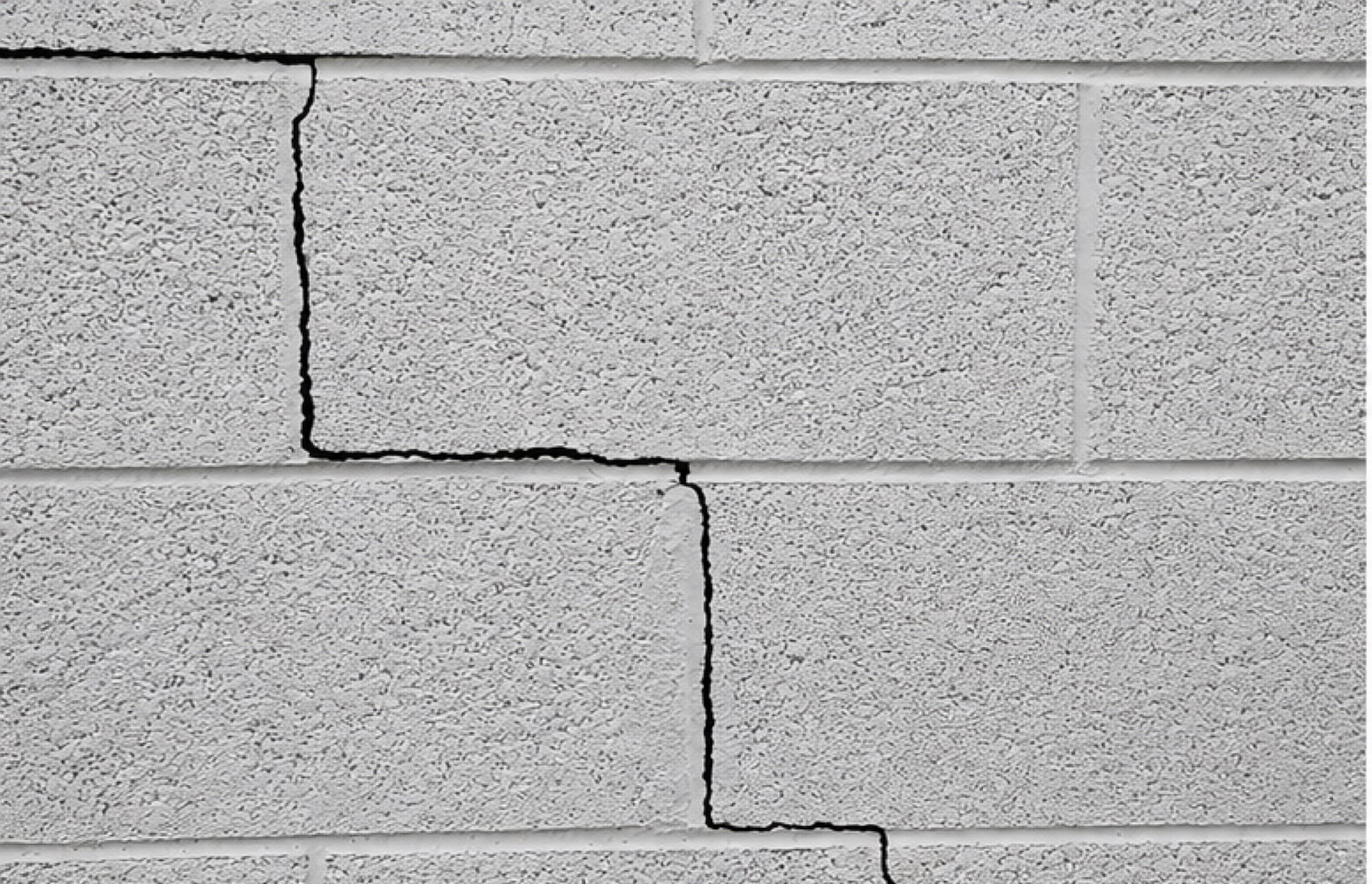 A stair-step crack following the mortar joints of a concrete block foundation wall